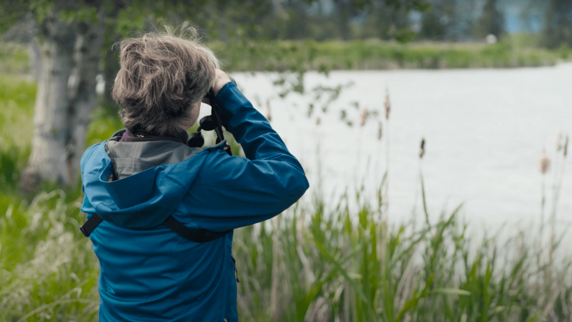 An image of a woman looking out onto a lake.