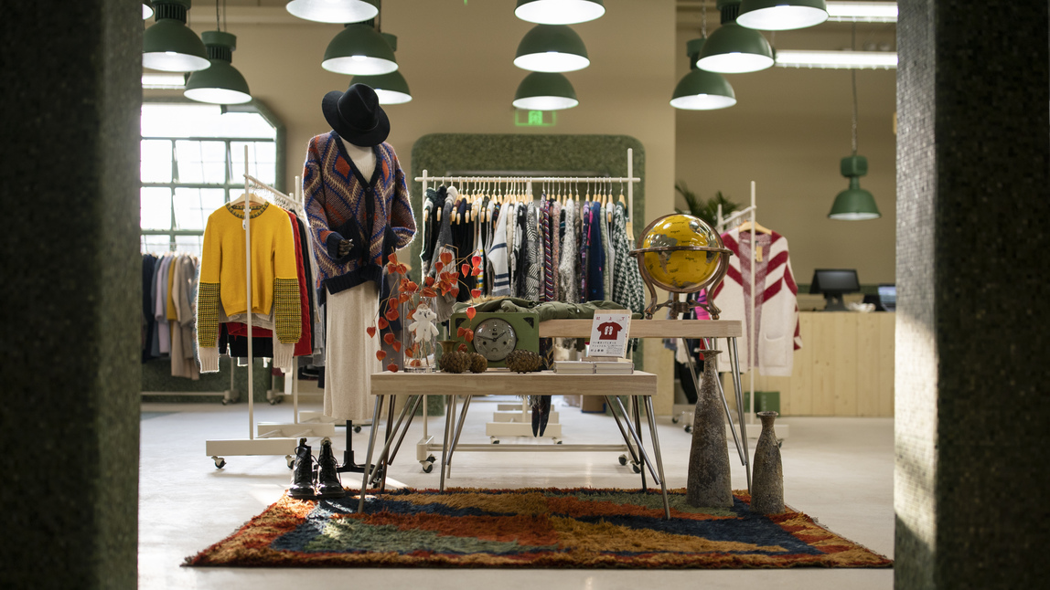 An image of some clothes and other items on a table in a shop. 