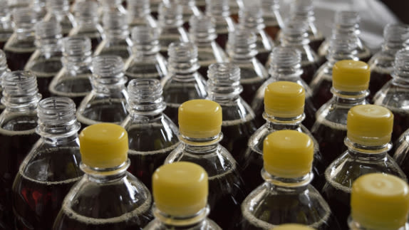 Rows of plastics bottles, some with yellow caps and some without