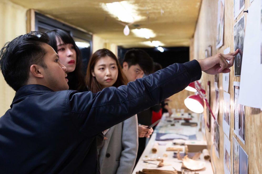 people pointing to wall display