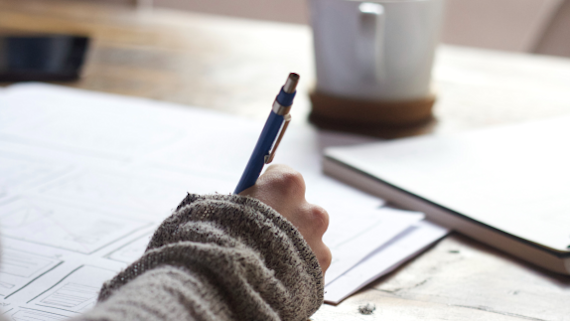Hand and pen close up, writing notes.