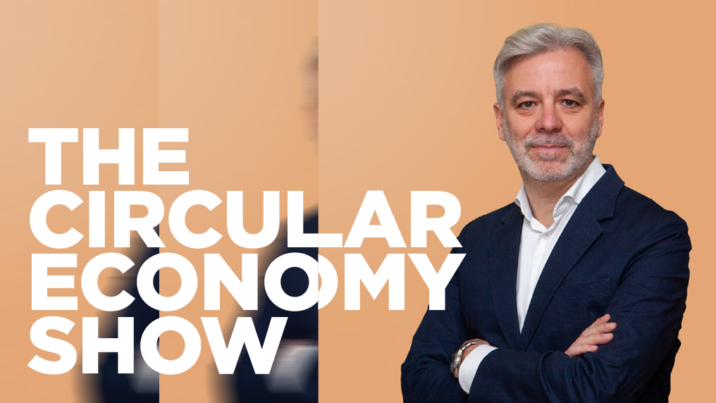 Man with arms folded and grey hair, circular economy show logo on a peach background