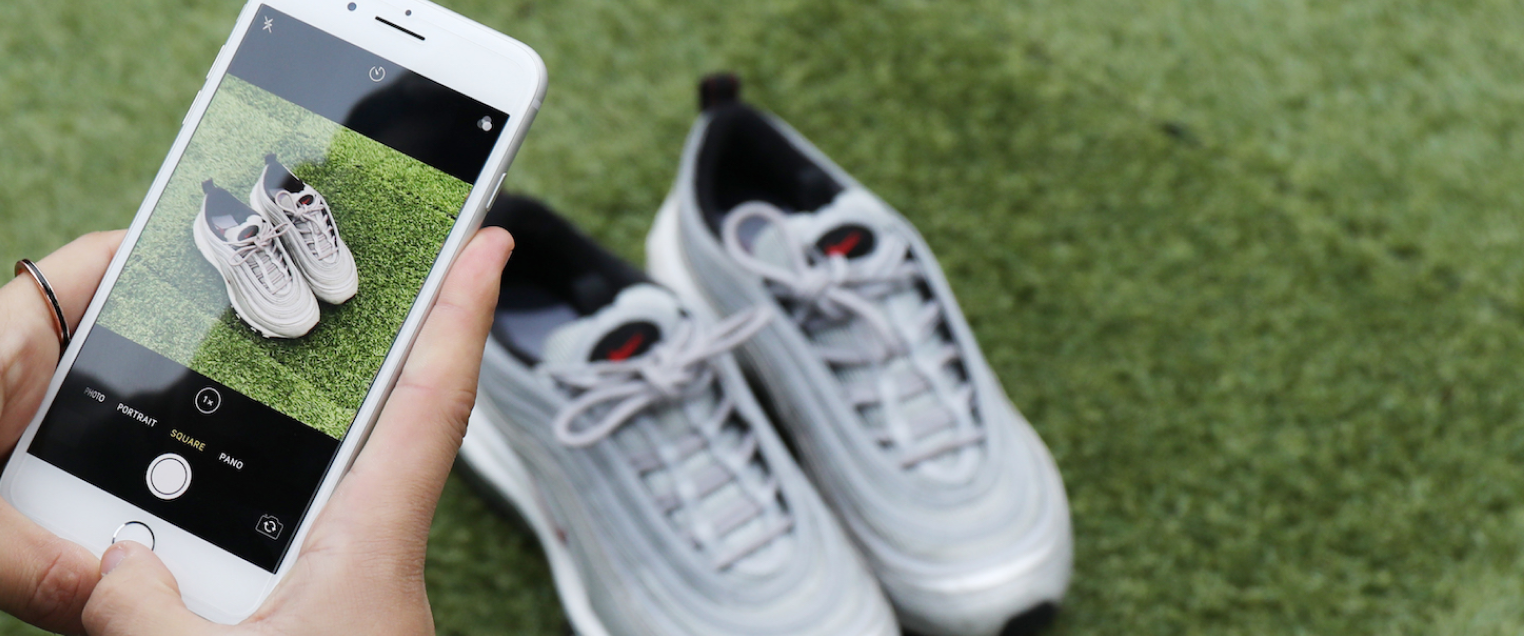 Person taking photo of shoes using mobile phone