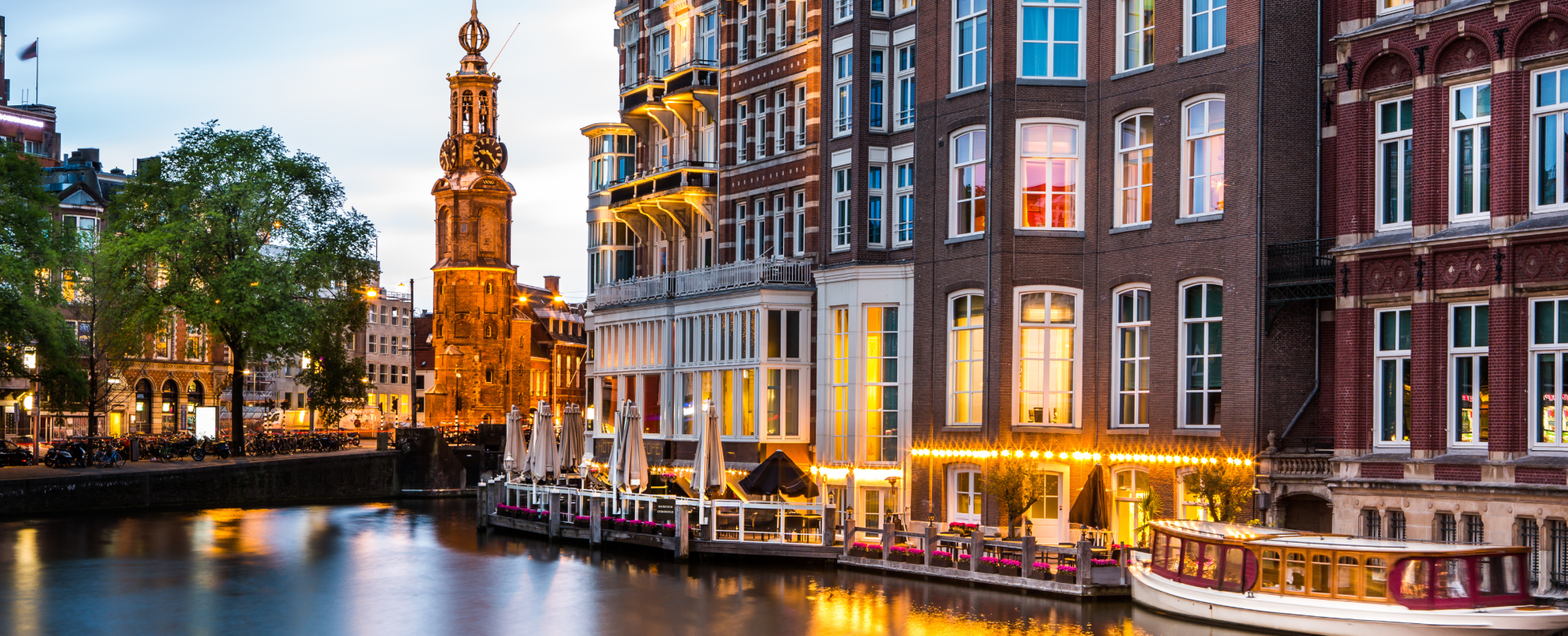 Amsterdam cityscape with the Mint tower at dusk.
