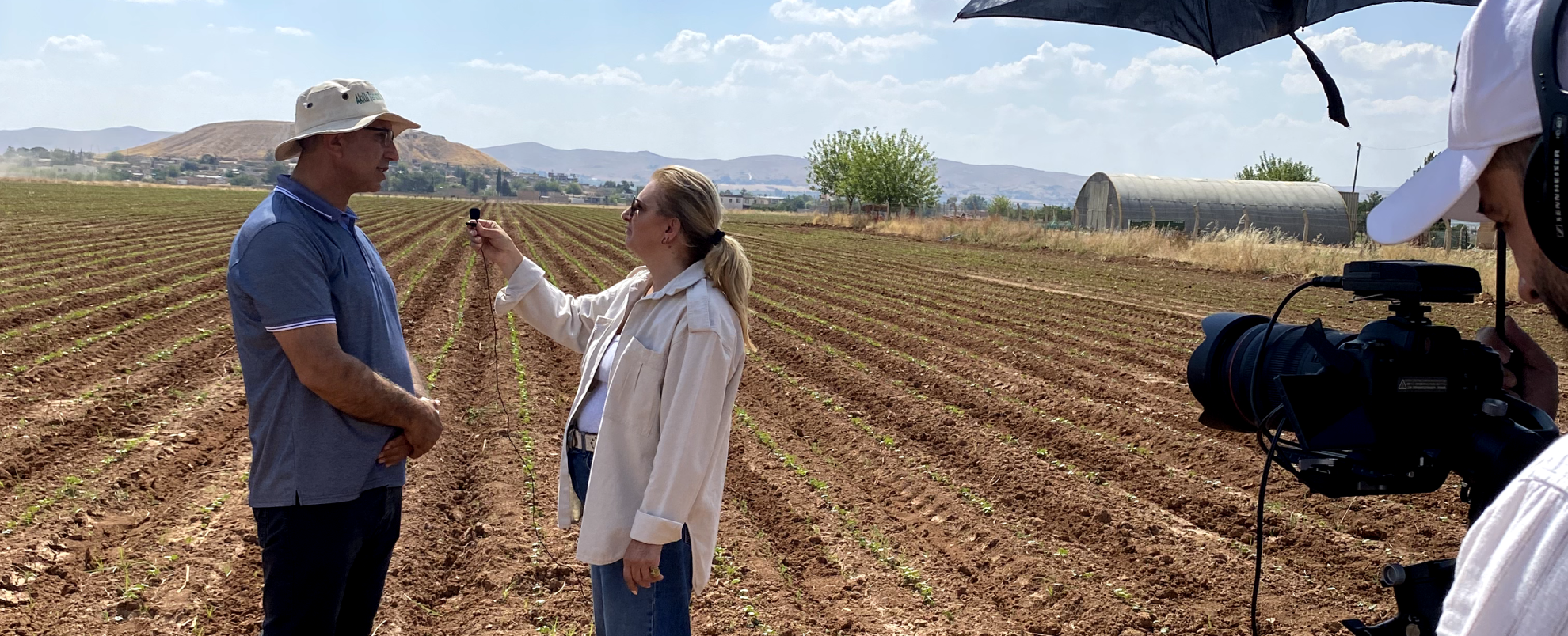 A women interviewing a man in a field