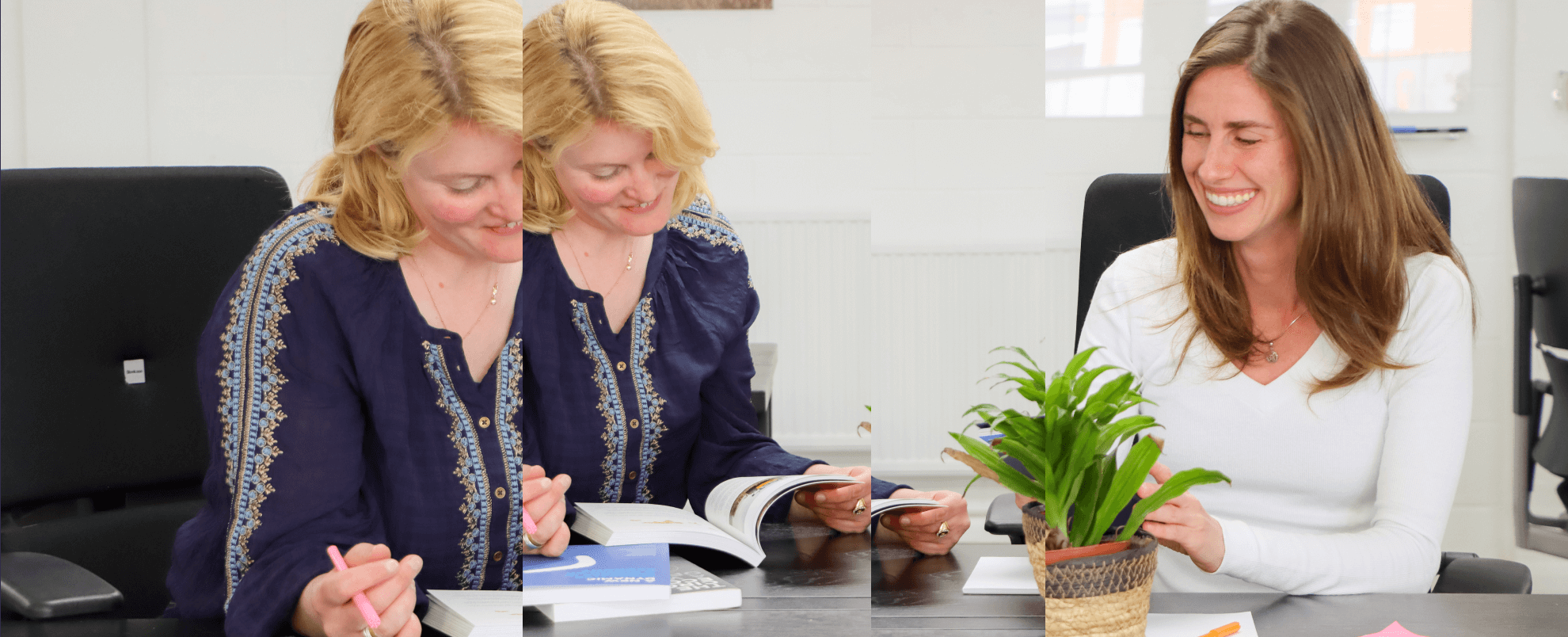 Two people sat at a desk looking at a book