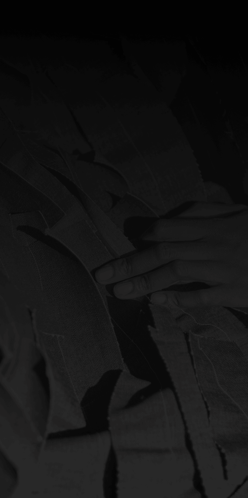 A hand sorting out cut up clothing ready to be remade