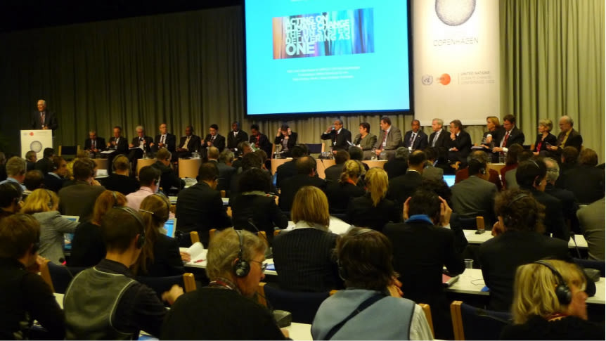 large audience of people at event with panel of people on stage