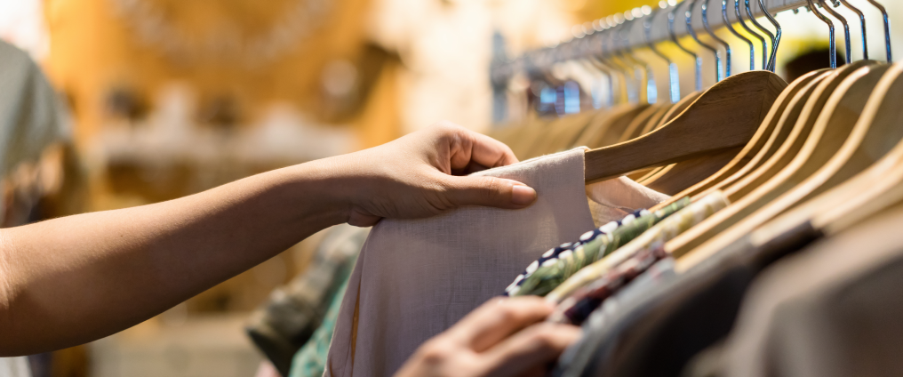 person selecting clothes from clothes rail