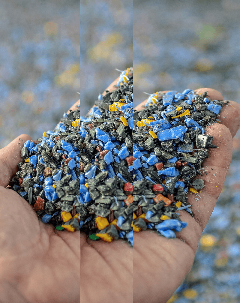 A hand holding plastic pellets