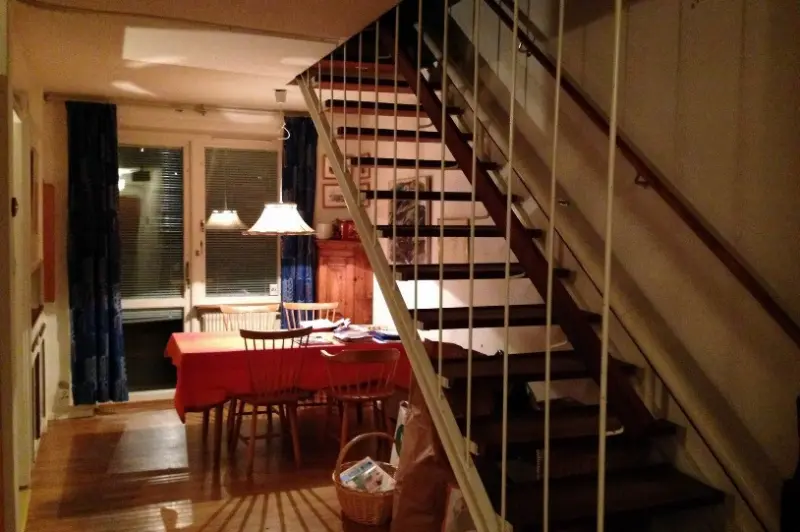 Exempel på trappa i tvåvåningshusen. Trappräcke av vitmålat smide och ledstång av teak.