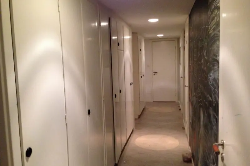 Korridor med ursprungliga garderobsdörrar och handtag av bakelit.