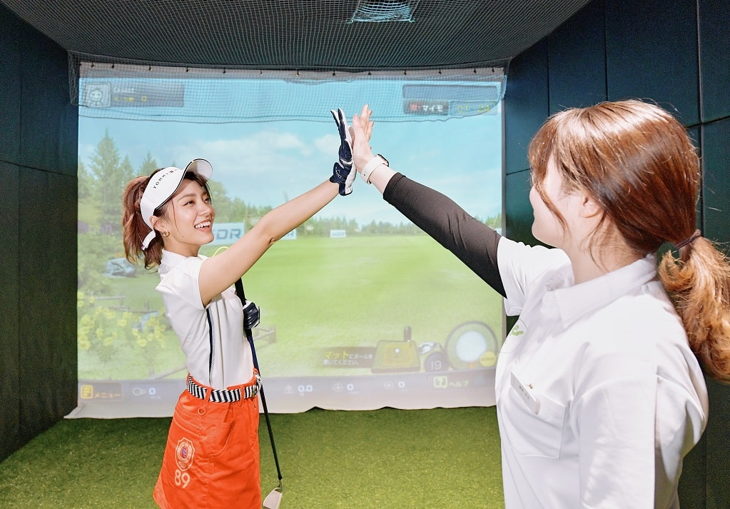 ハイタッチする女性トレーナーと女性生徒