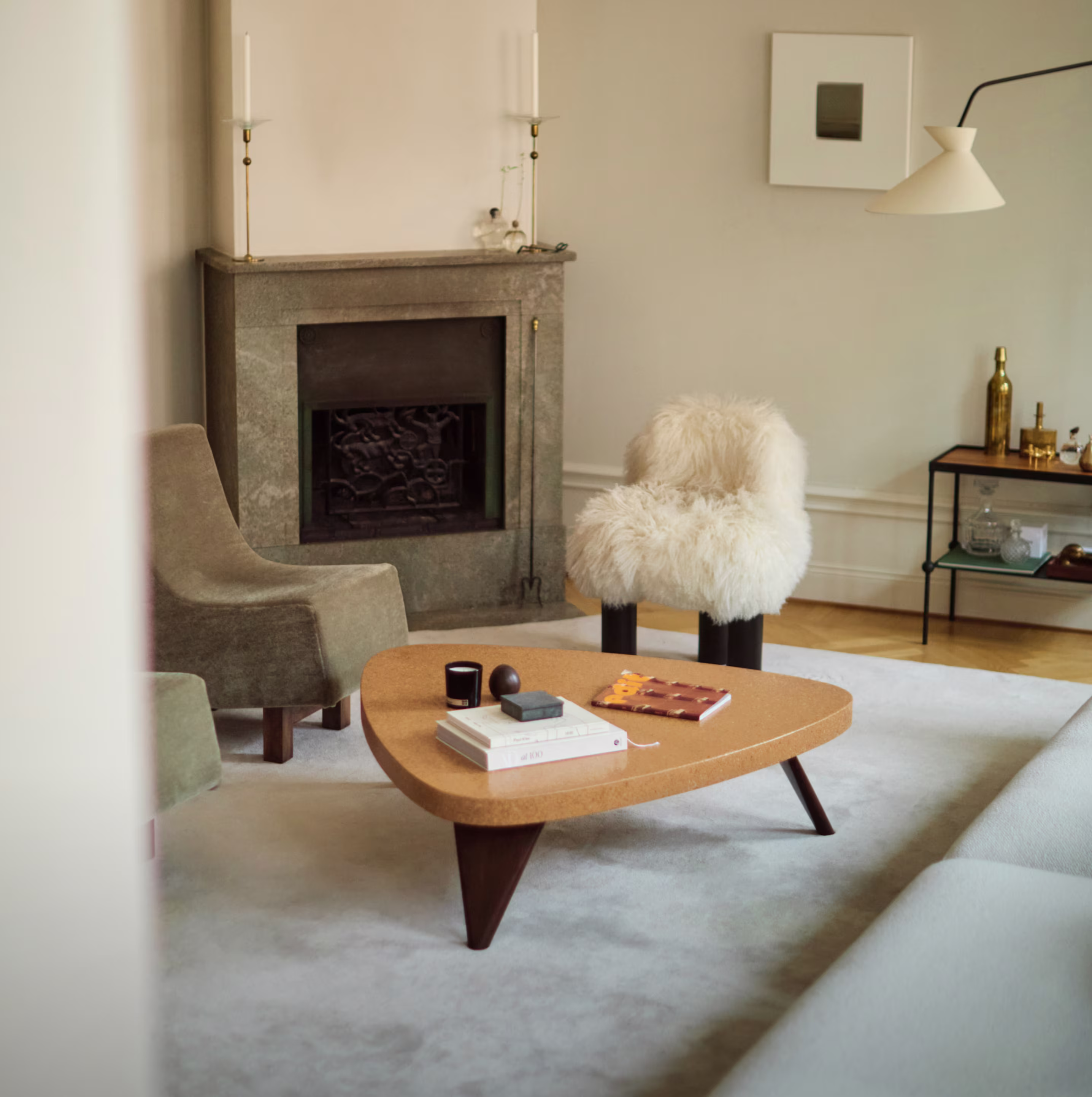 Living room with Paul T. Frankl’s Plectrum coffee table in cork and wood, surrounded by designer furniture including an armchair.