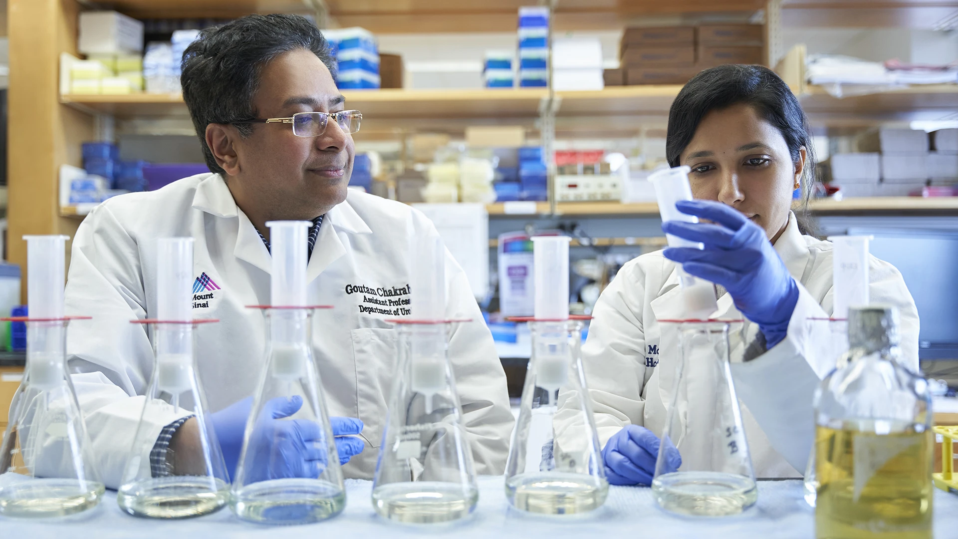 Goutam Chakraborty, PhD (left), works with lab member Prathiksha Prabhakaraalva , PhD (right), to explore how deletions and mutations of genes implicated in DNA damage repair, such as BRCA2, could turn prostate cancer into an aggressive and treatment-resistant disease.