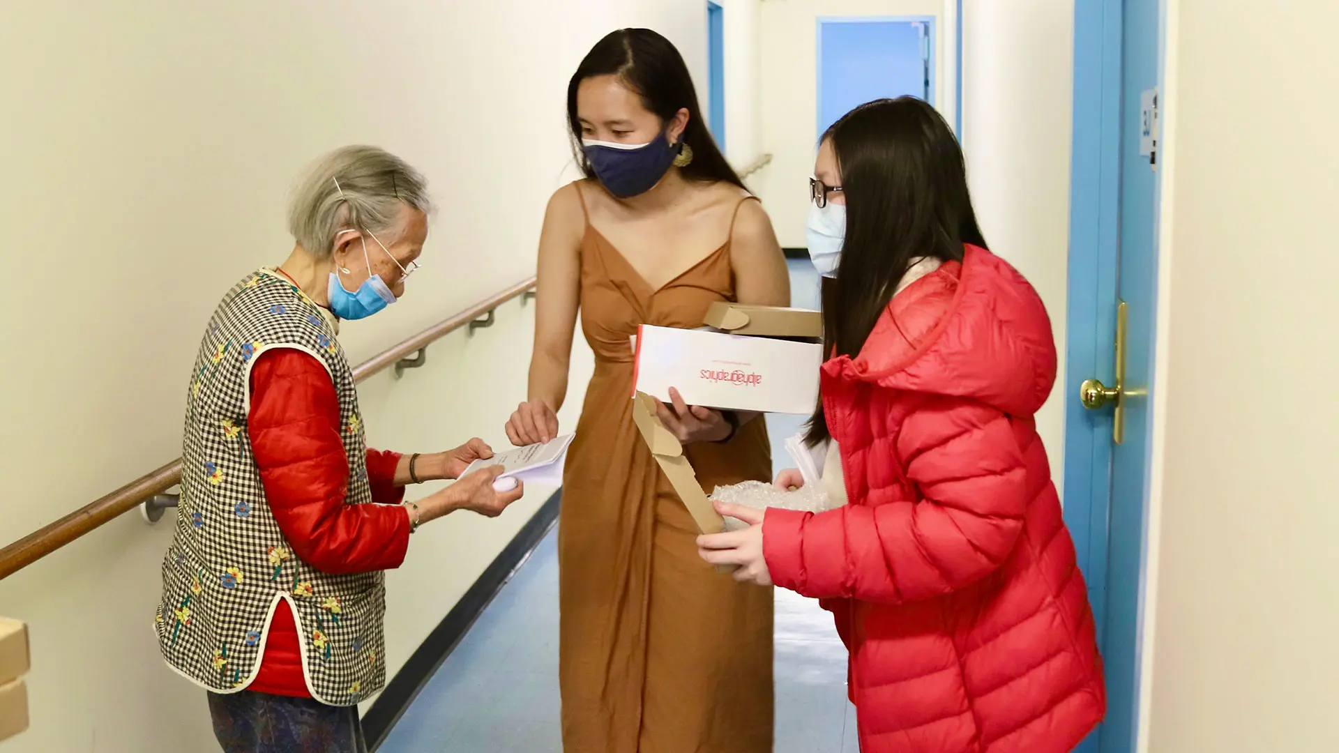 Michelle Tran and a high school volunteer distribute a personal safety alarm and a booklet about how to report a hate crime to an elderly resident in Manhattan's Chinatown in 2021.