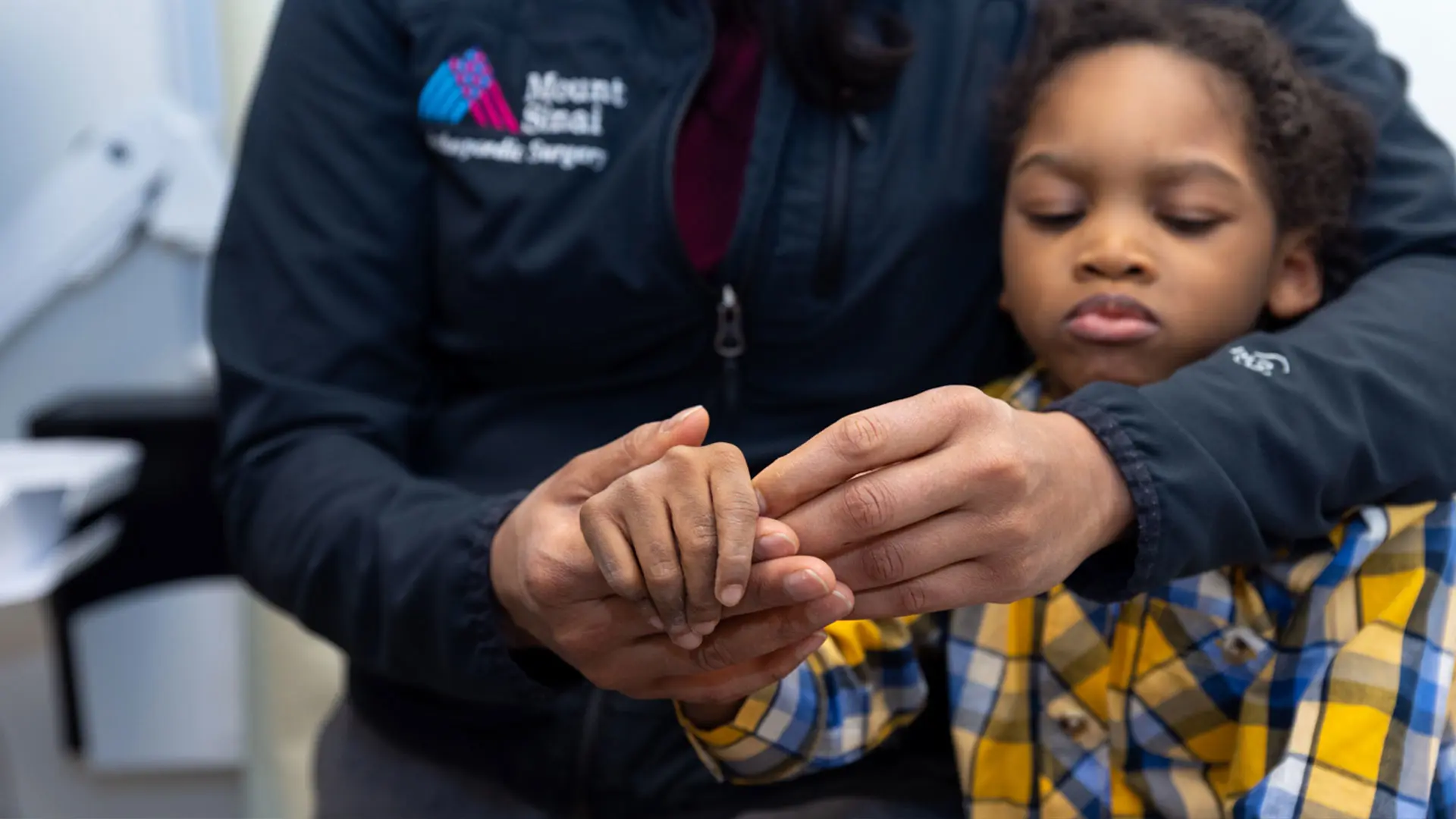 Davanis Bowen, a six-year-old patient with spastic quadriplegia, has his finger range of motion examined. 


