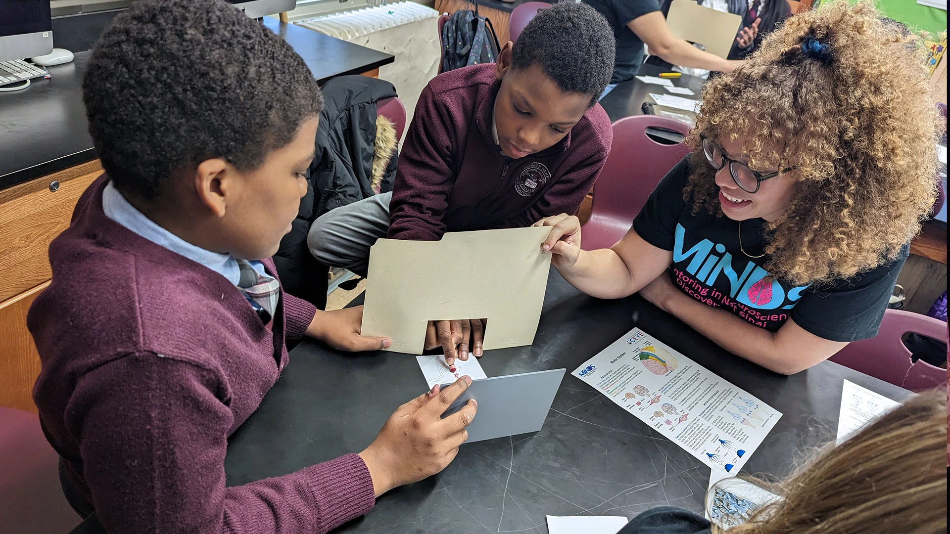 P.S. 171 Patrick Henry seventh graders attempt to draw a star while only looking at their hand in a mirror. Rachel Fisher-Foye, a Neuroscience PhD student at Mount Sinai, stands by to explain how the visual system and the motor system work together to execute different movements.
