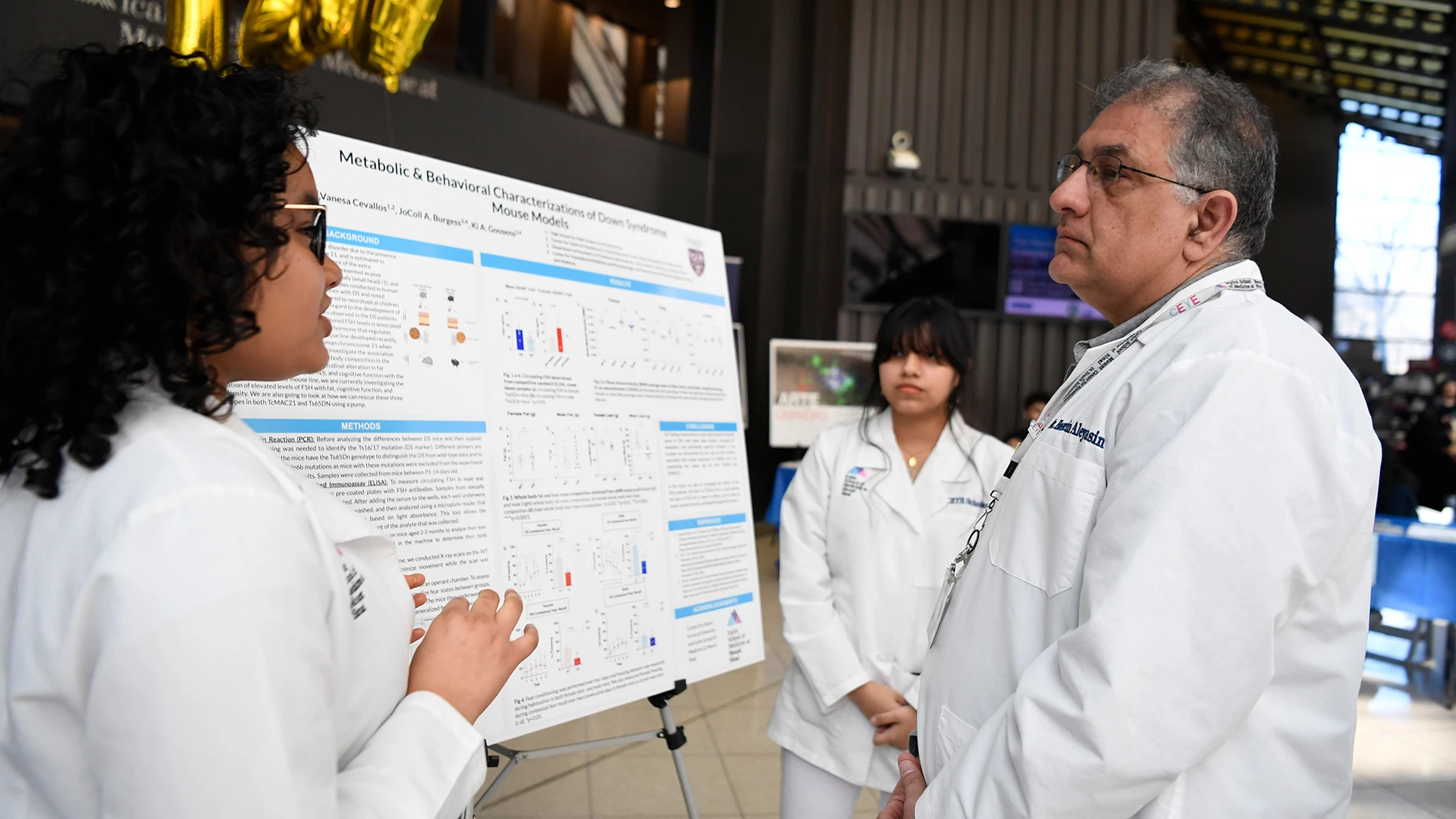 Hossein Aleyasin, MD, PhD, at a student poster presentation with Heidy Gonzales, left, and Vanesa Cevallos. 