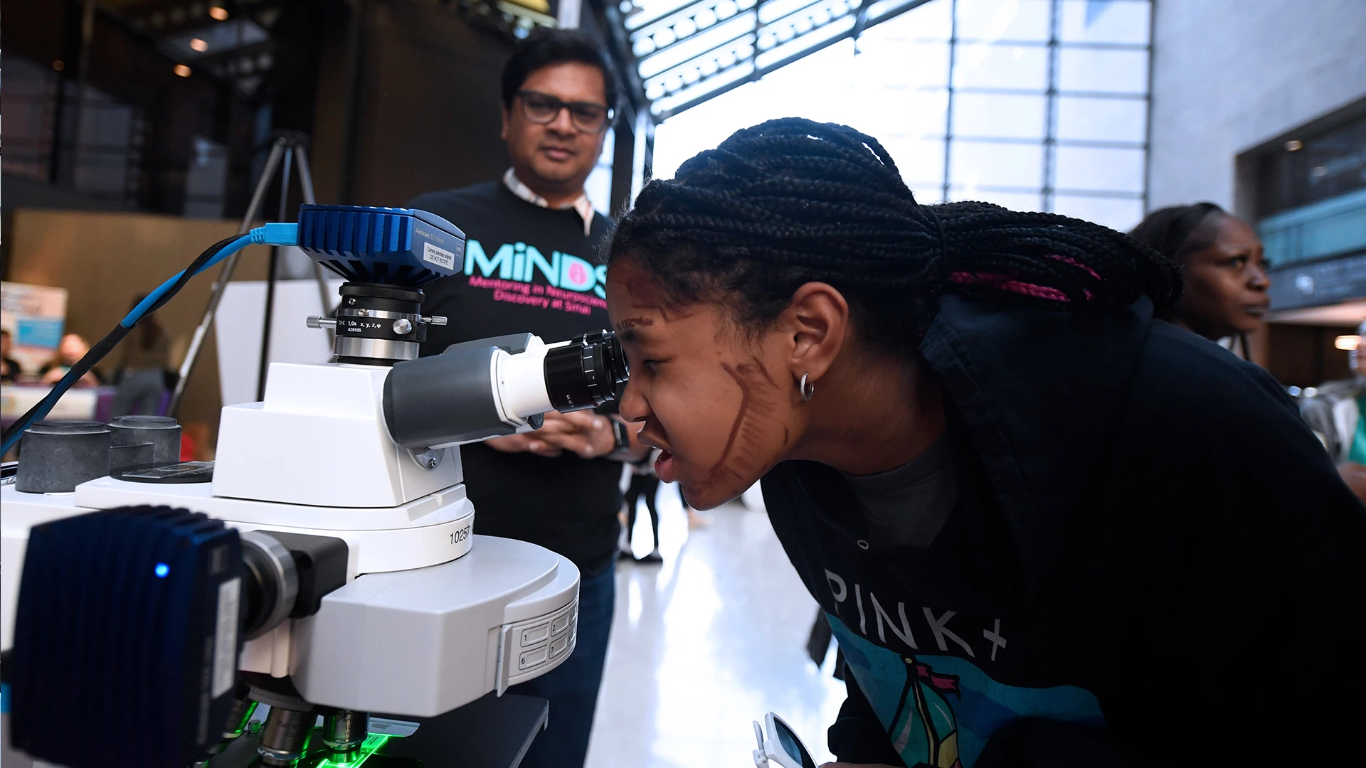 Arun Narasimhan, PhD, Senior Scientist at the Microscopy and Advanced Bioimaging CoRE, explains the nucleus, scaffolding, and energy center of cells to a curious Brain Fair attendee.