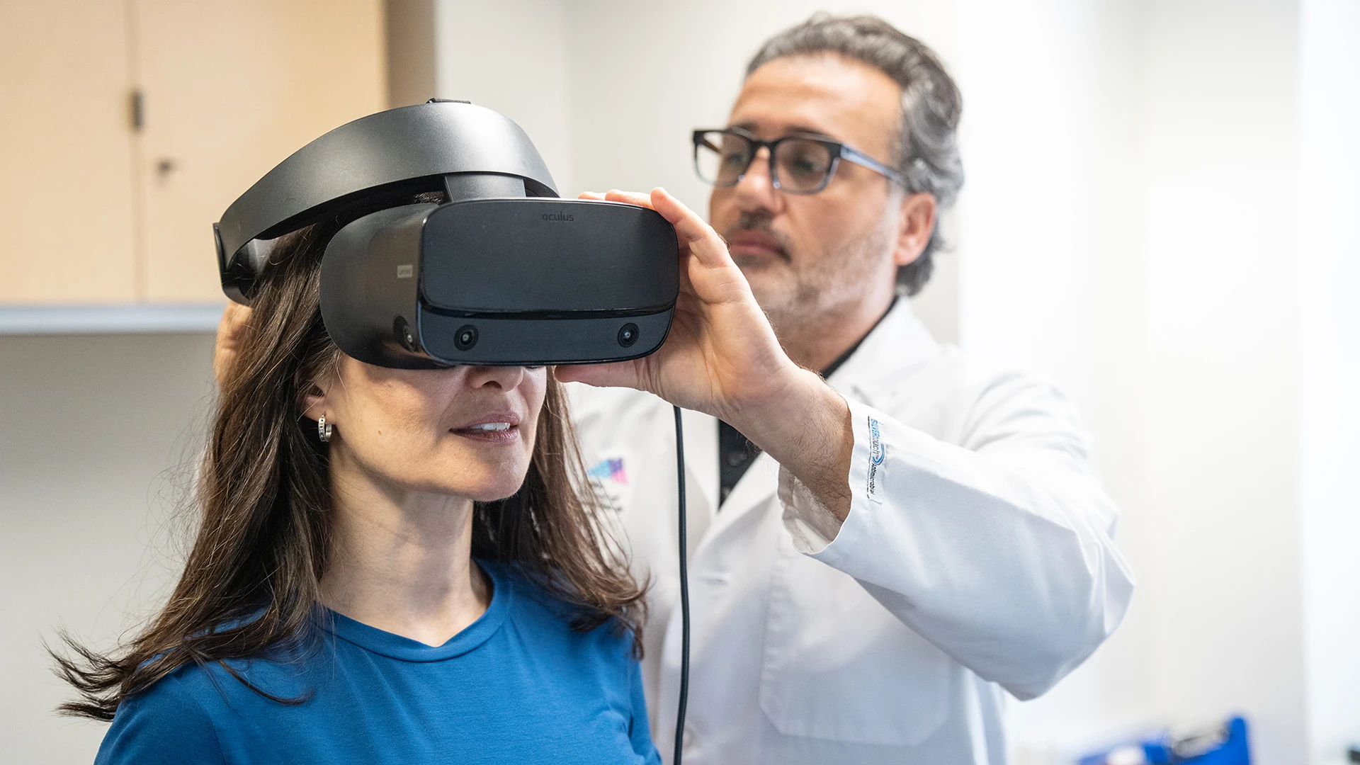 Dr. Daşdöğen placing VR goggles on a patient.