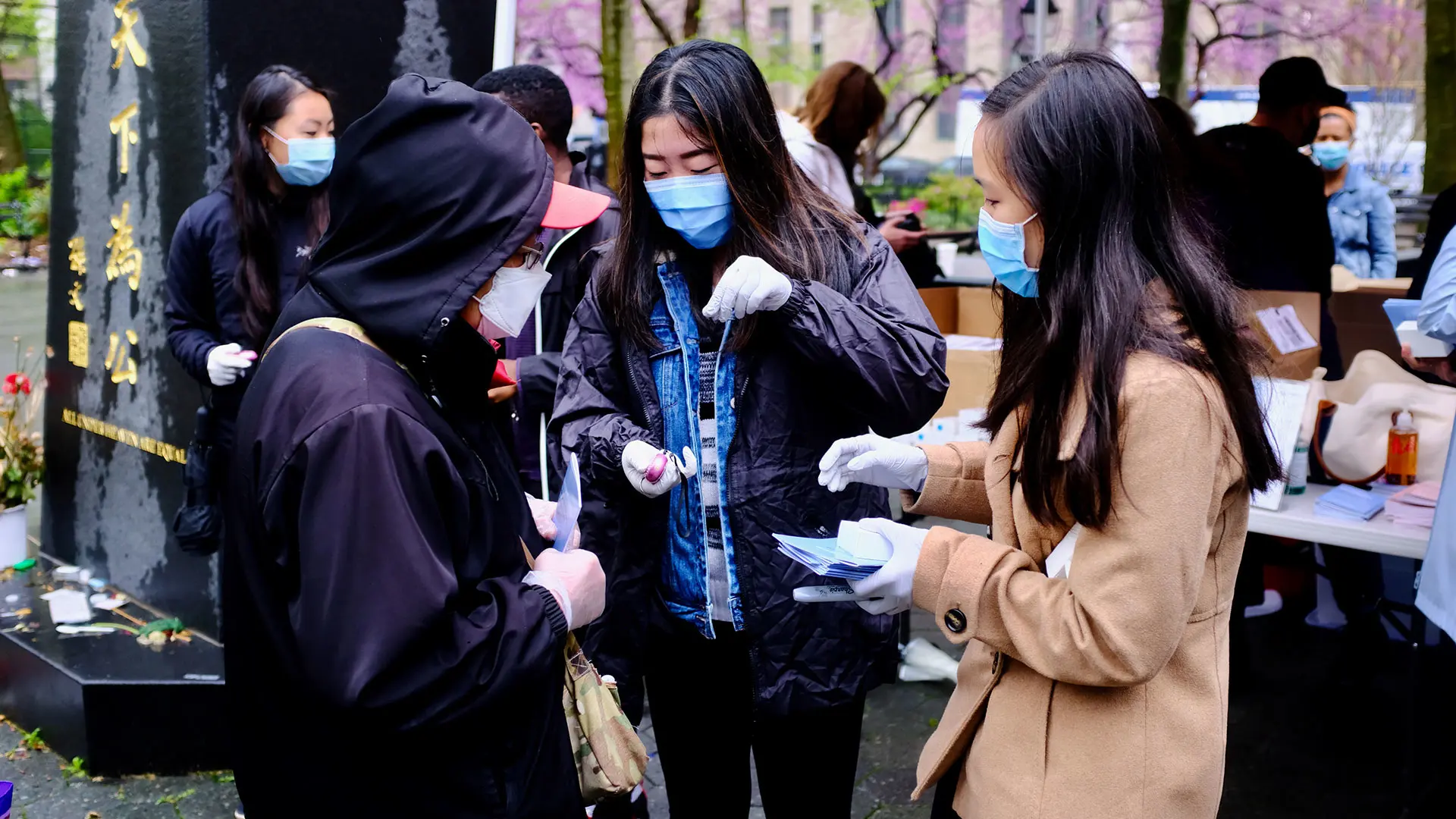 Michelle Tran, right, with Alyce Kuo, now a fourth-year medical student, gave a personal safety alarm and a booklet about how to report a hate crime to an Asian elder in Manhattan's Chinatown in 2021.