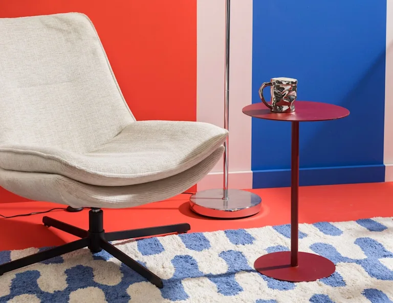 Retro sfeersetting met een fauteuil, bijzettafel en vloerlamp