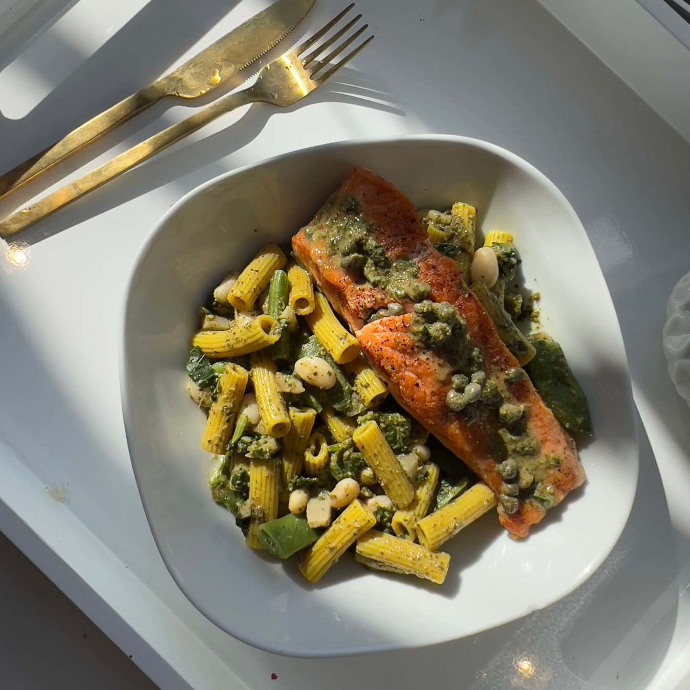 White Bean and spinach Pesto Pasta With Baked Salmon on top.