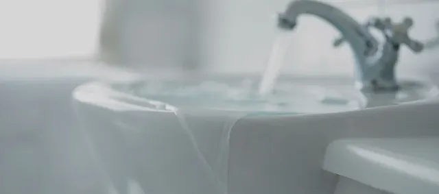 Bathroom sink overflowing with water.