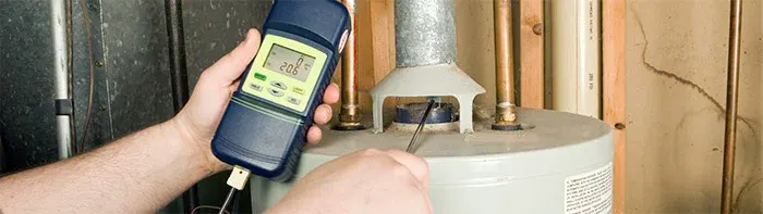 person testing gas leakage from a water heater