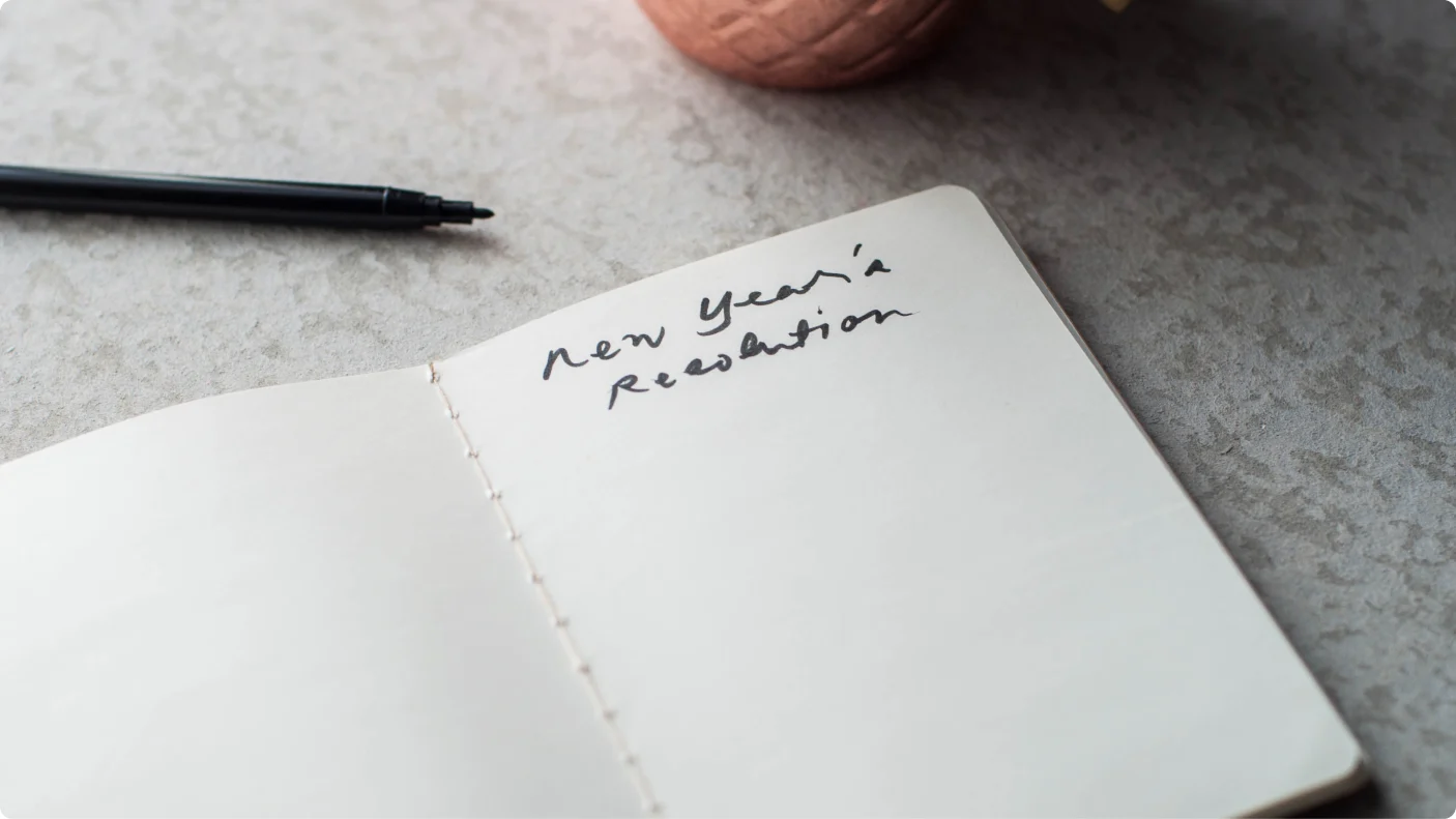 open notebook on countertop with new year's resolution written on a page