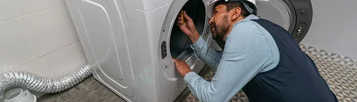 repairman fixing washer and dryer