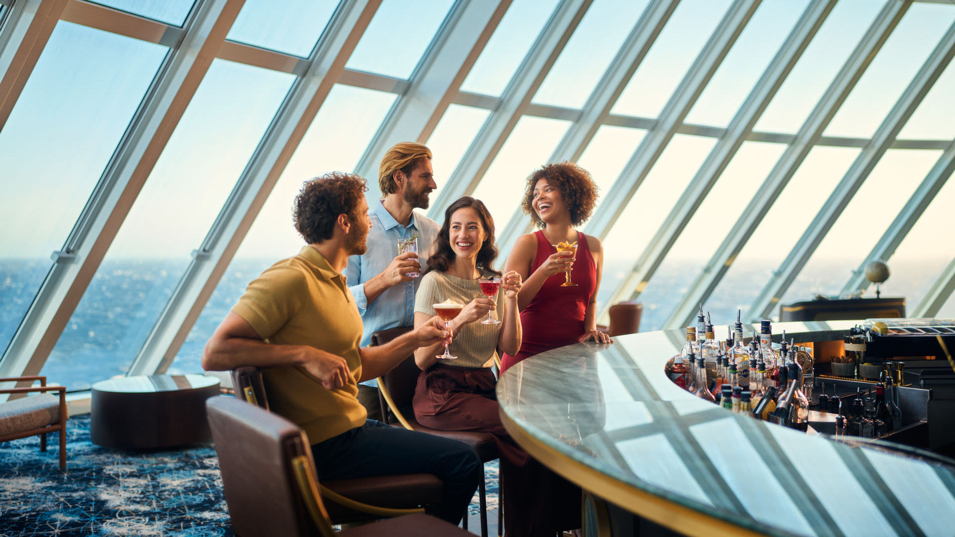 Zwei Paare genießen ihre Getränke und die Gemeinschaft in einer Bar mit tollem Ausblick auf das Meer.
