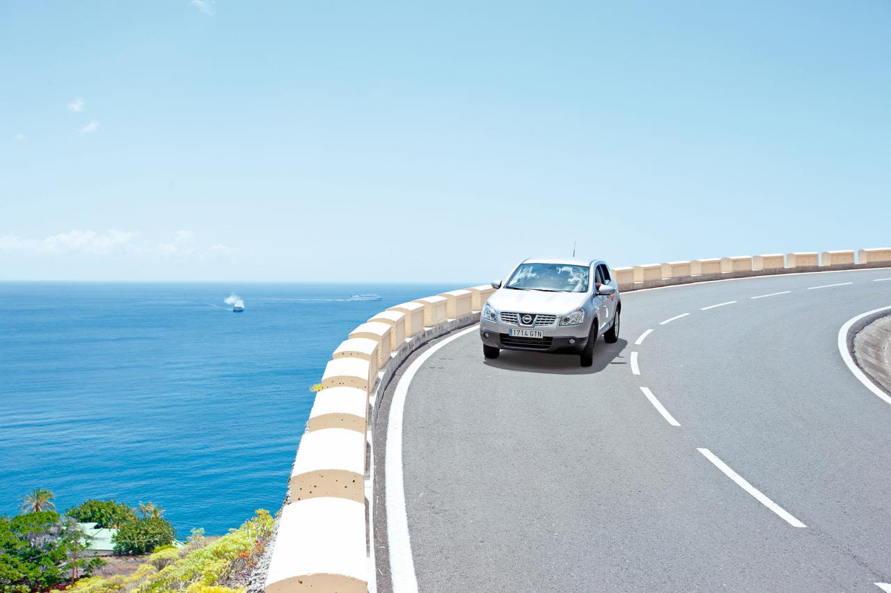 Car drives on a coastal road