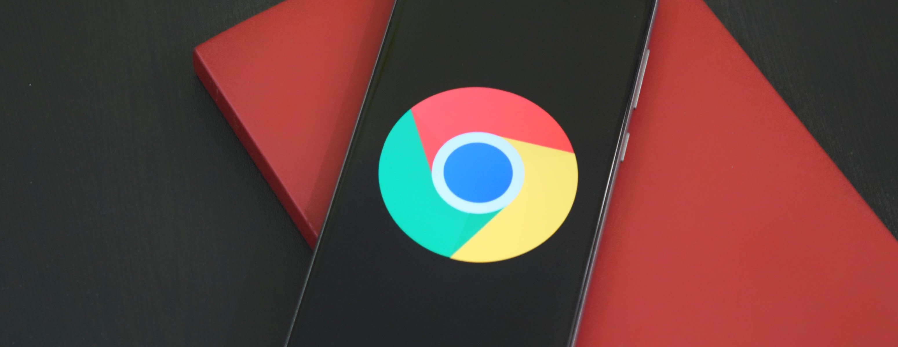 Mobile device on top of a book. Chrome logo presented on device screen.