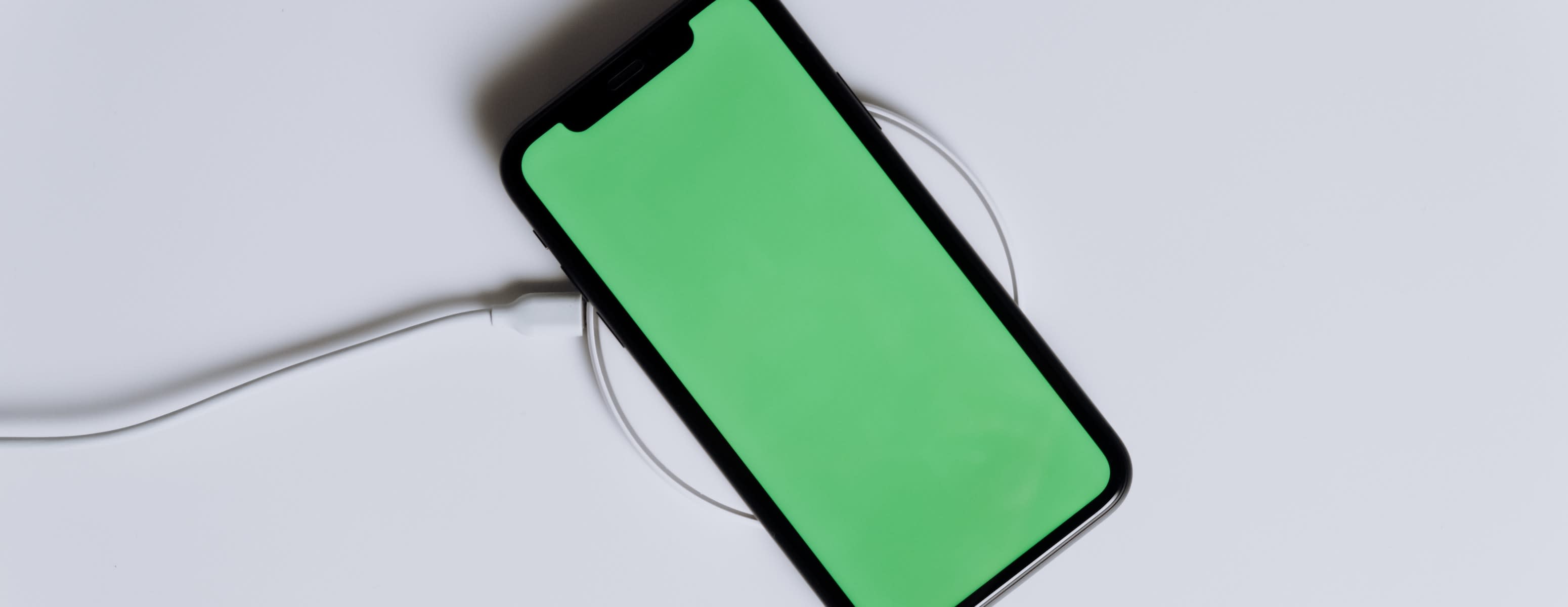 A mobile phone being wirelessly charged having full screen green