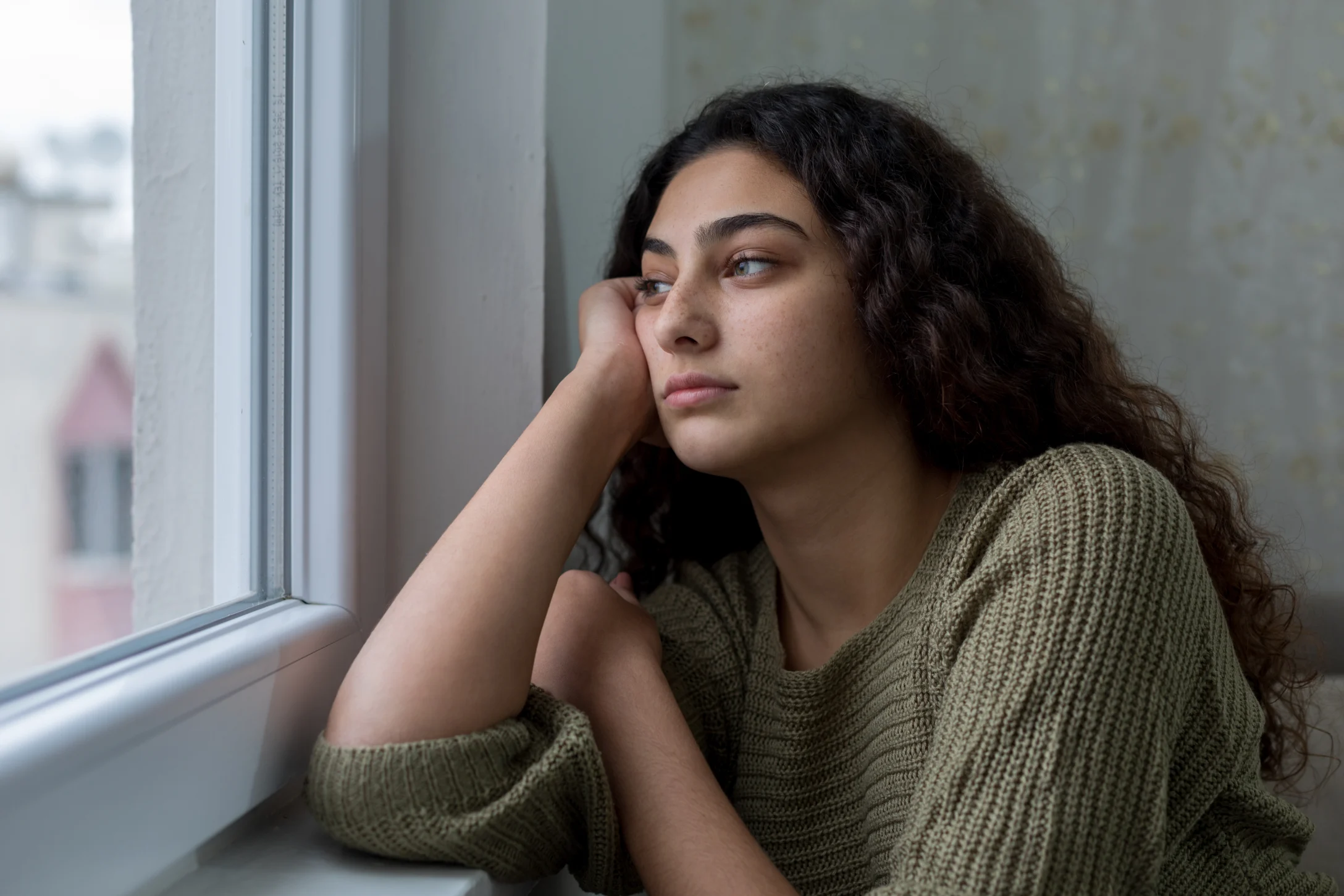 teen looking out window