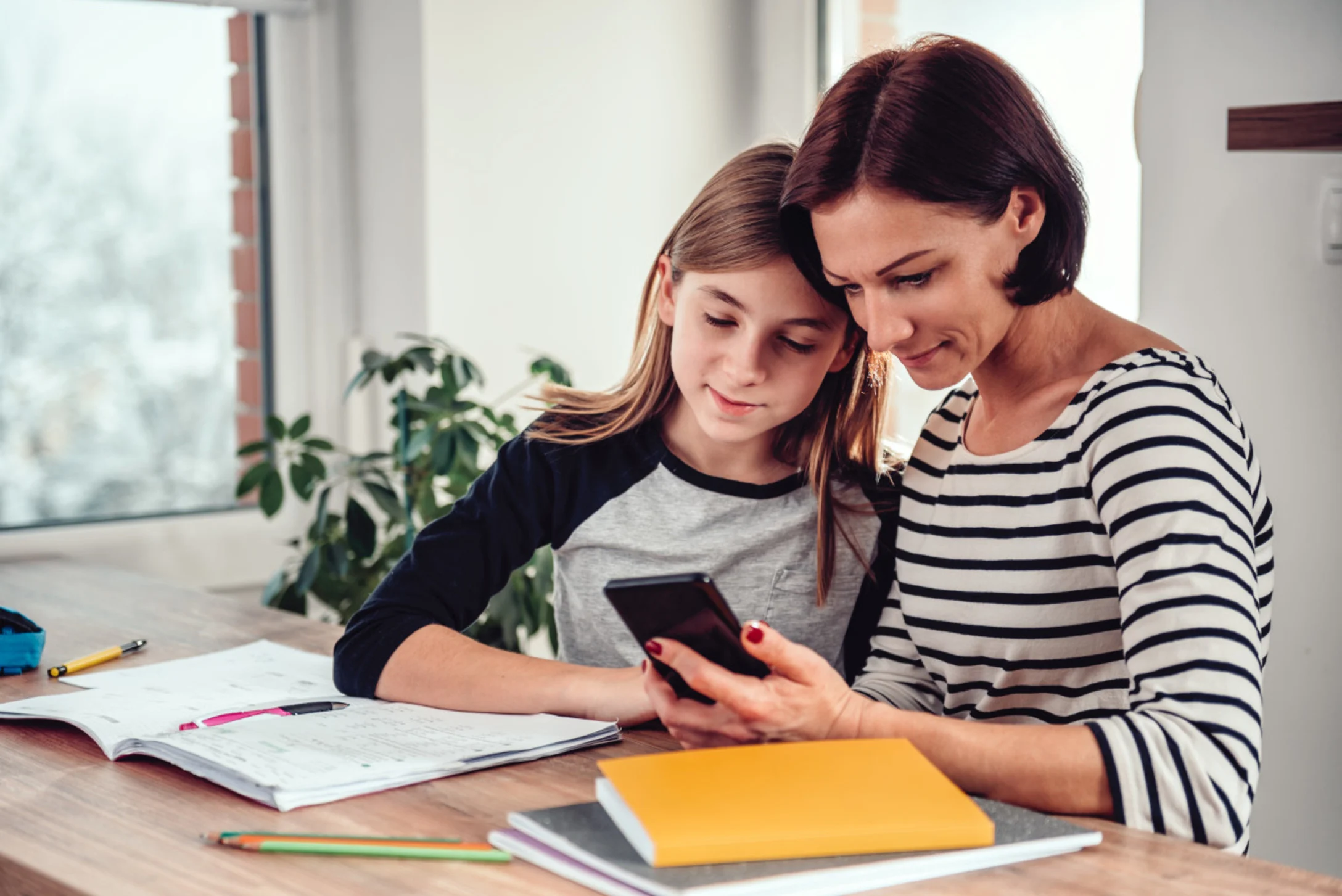 mom and teen with smartphone