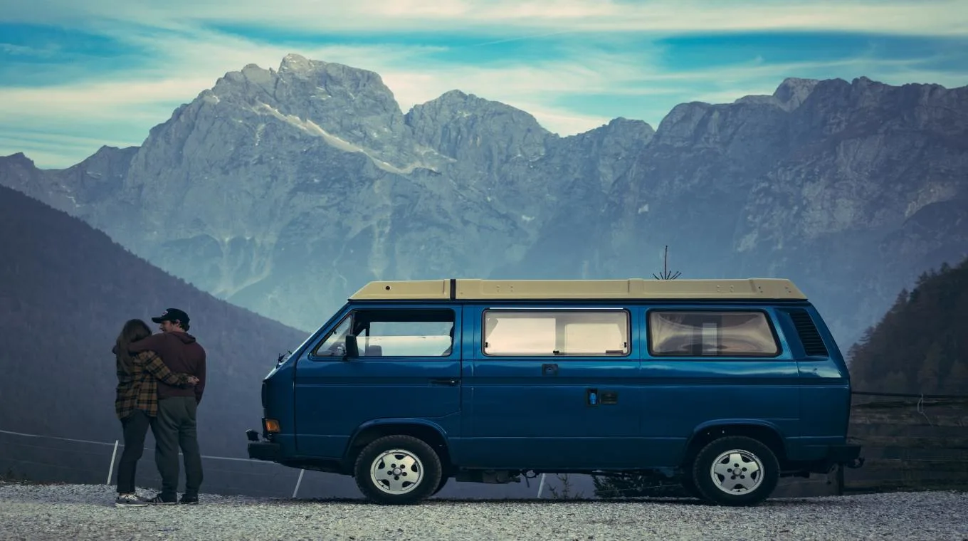 A couple on a road trip, looking at some mountains