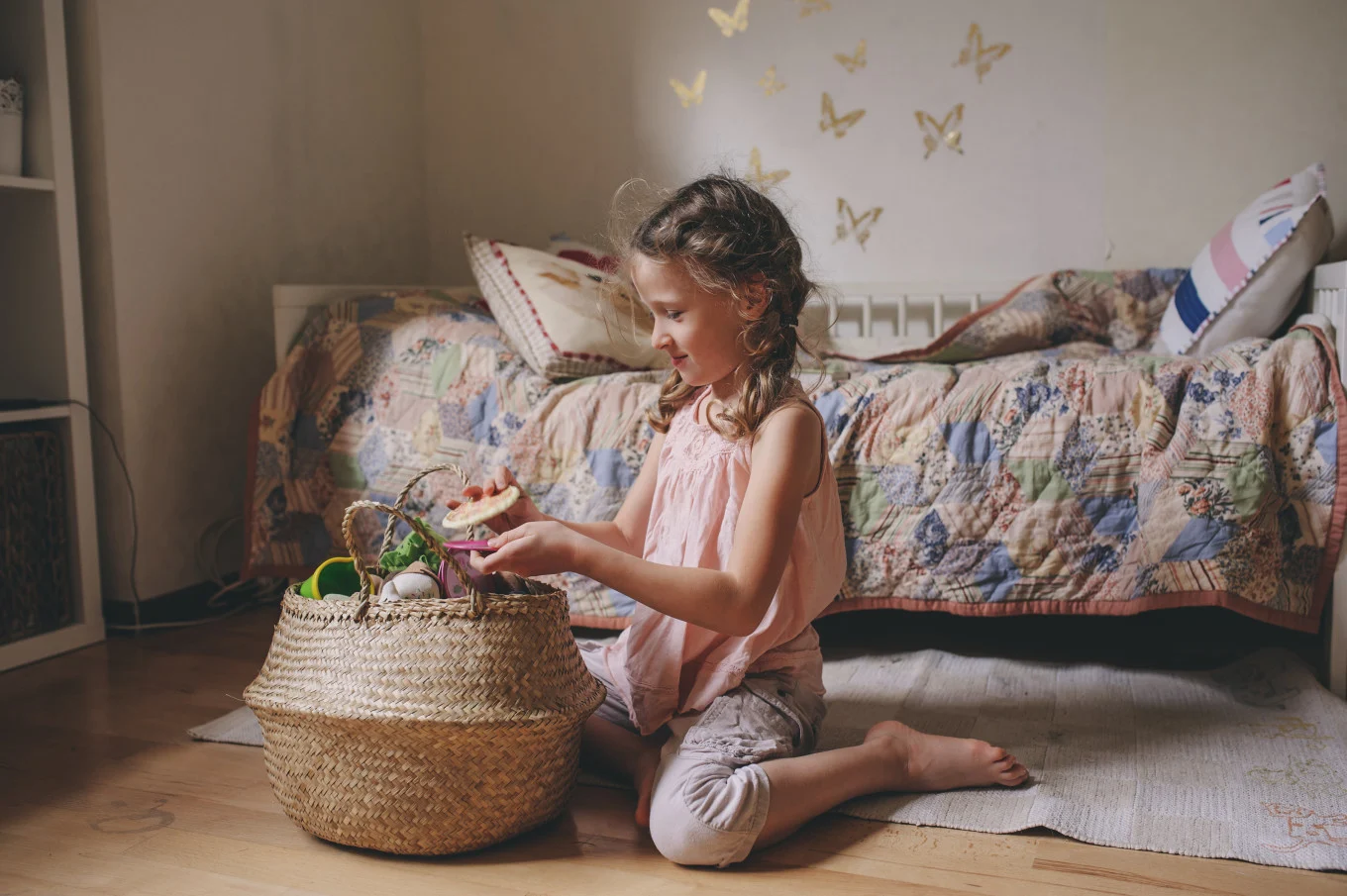 little girl putting toys in a basket