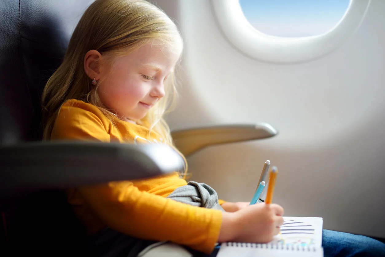 girl coloring on airplane
