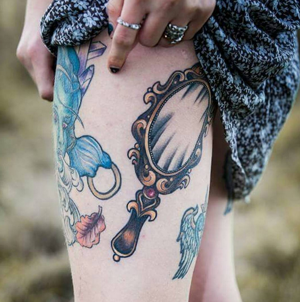 Ornamental style mirror tattoo on the left forearm