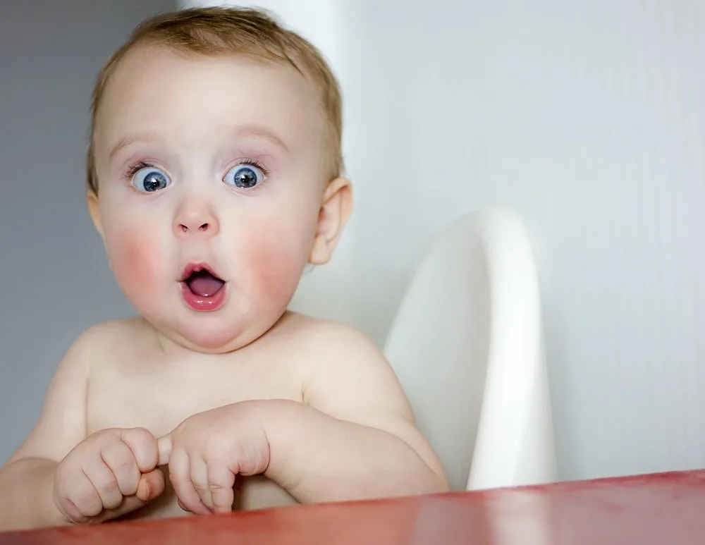 surprised kid sitting at table. child's eyes widened and mouth opened in amazement.