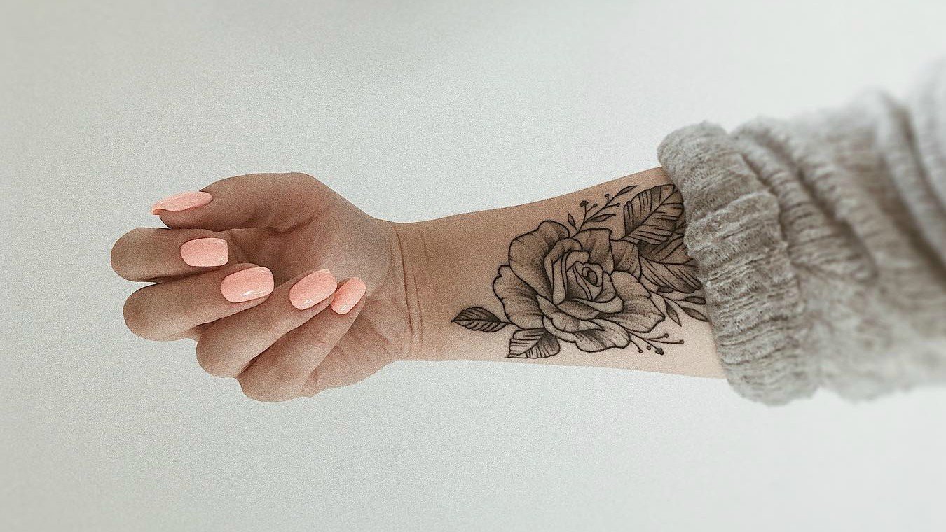 Colored rose tattoo on upper left thumb