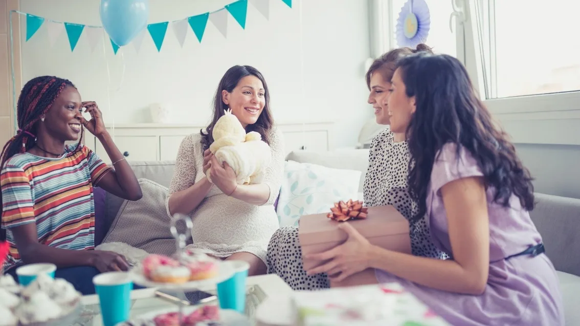 Women trade small gifts at an intimate baby shower