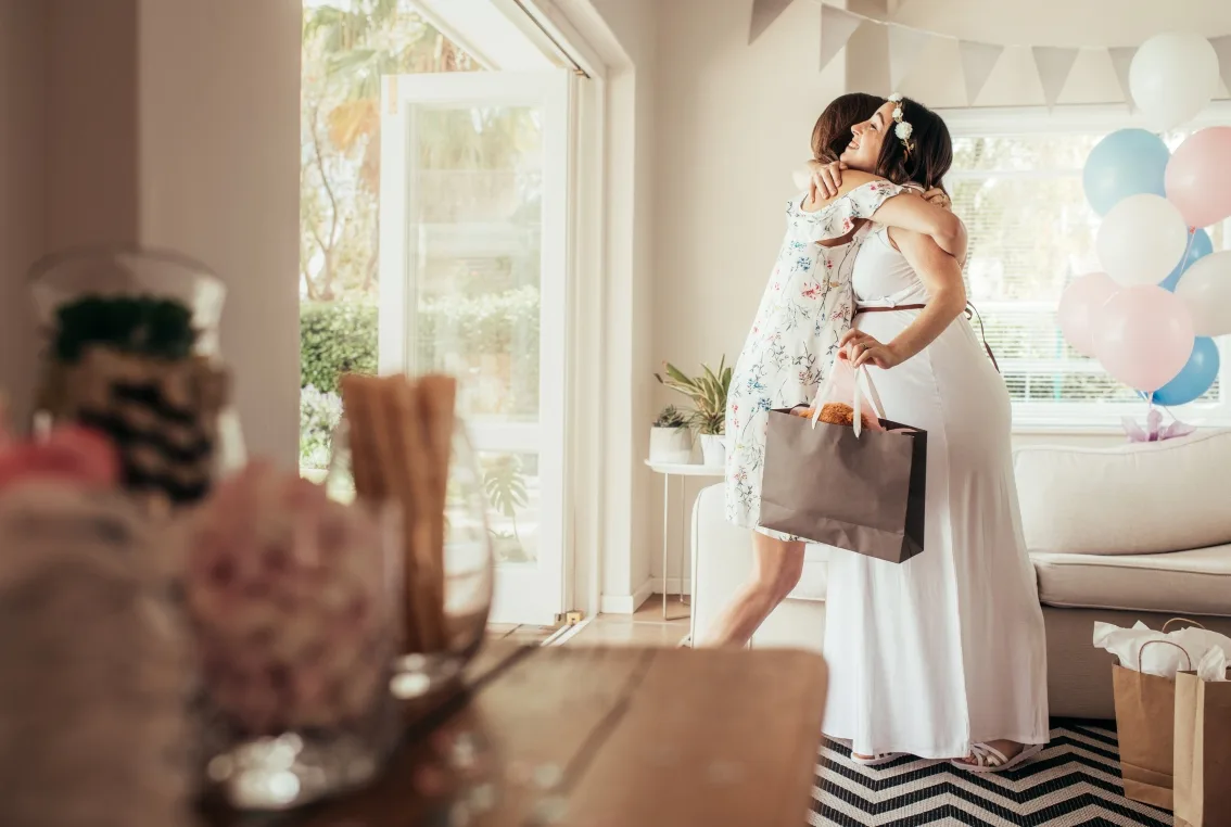 Pregnant mom hugs shower guest