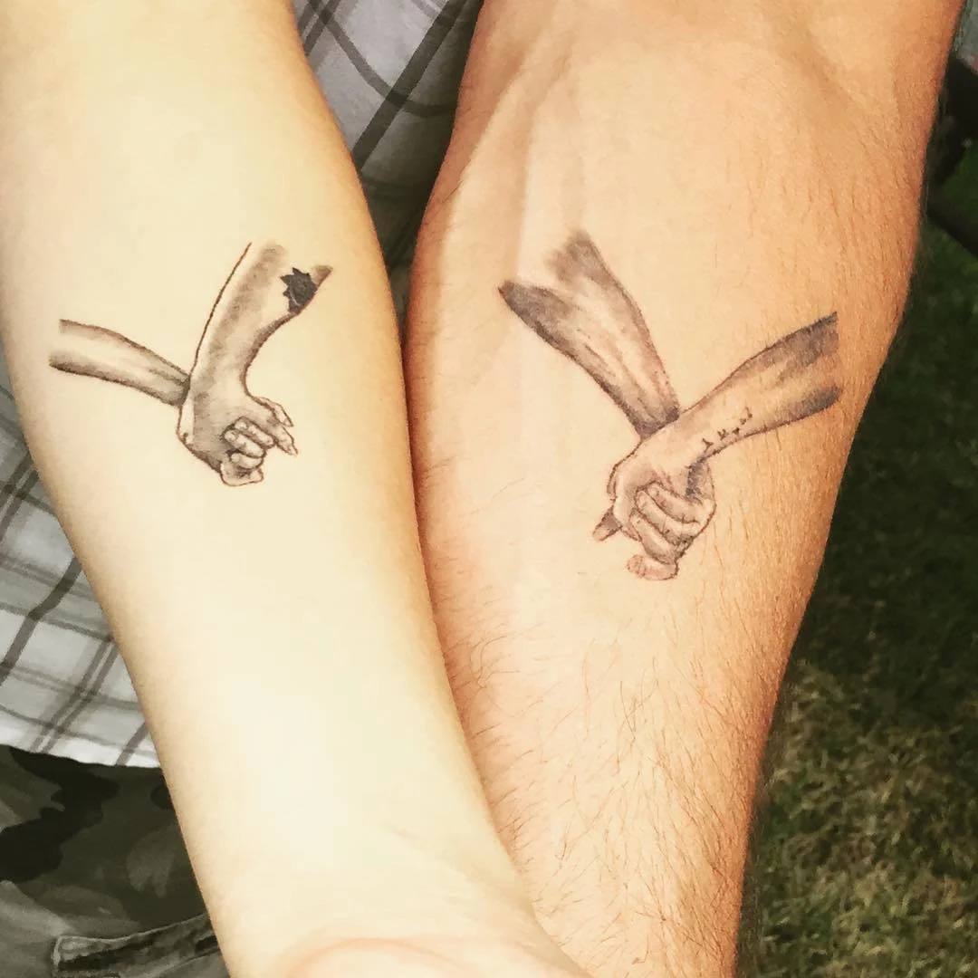 Hand Holding Father-Daughter Tattoos