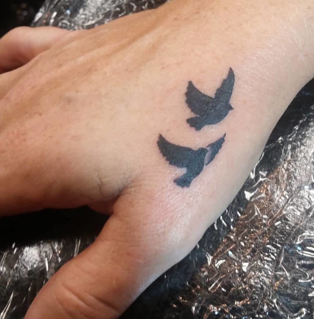 Tatuaje en la mano, pequeño pájaro negro Tatuaje en la mano, pequeño pájaro negro