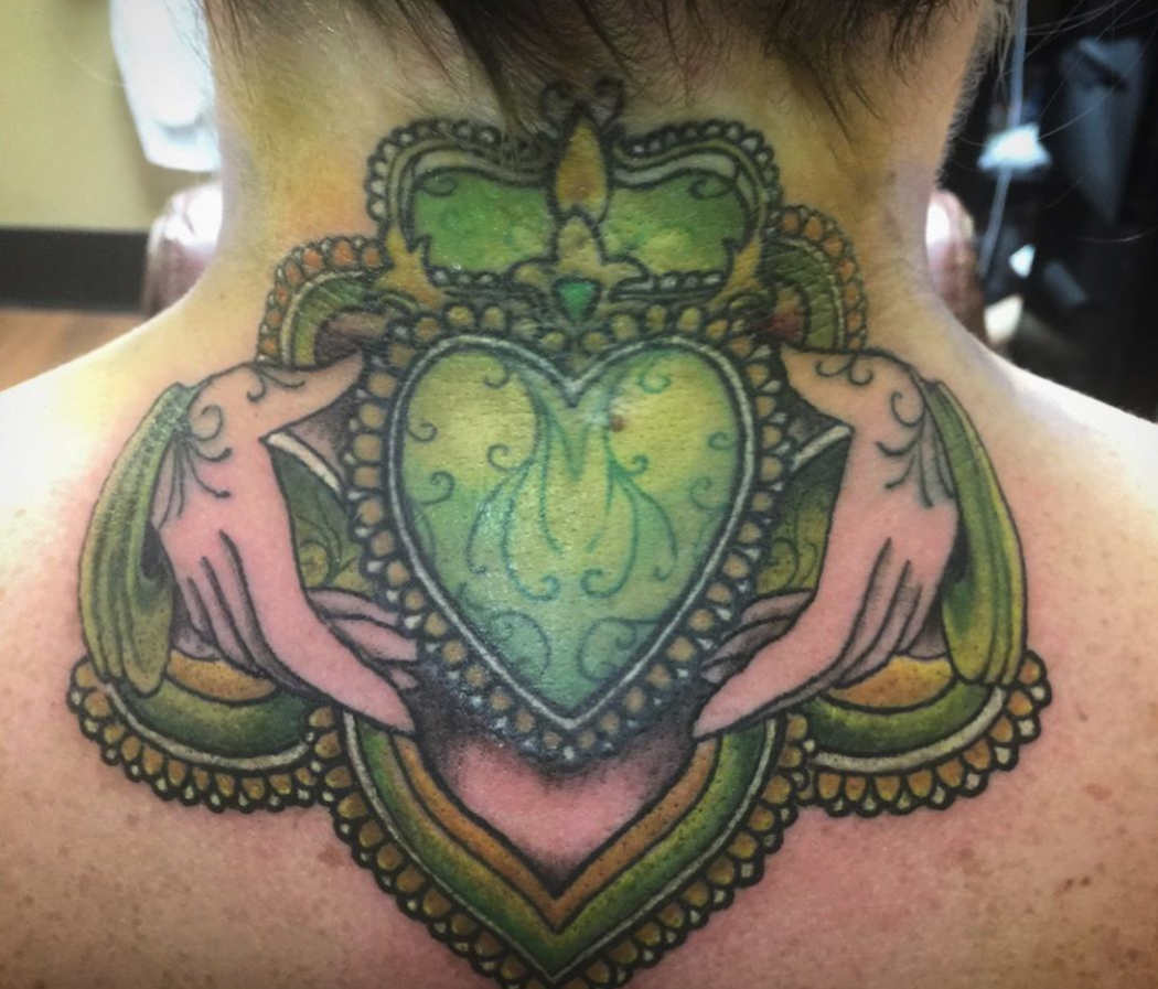 a Cross behind a claddagh ink with green and gold colors for st. Patrick's  day