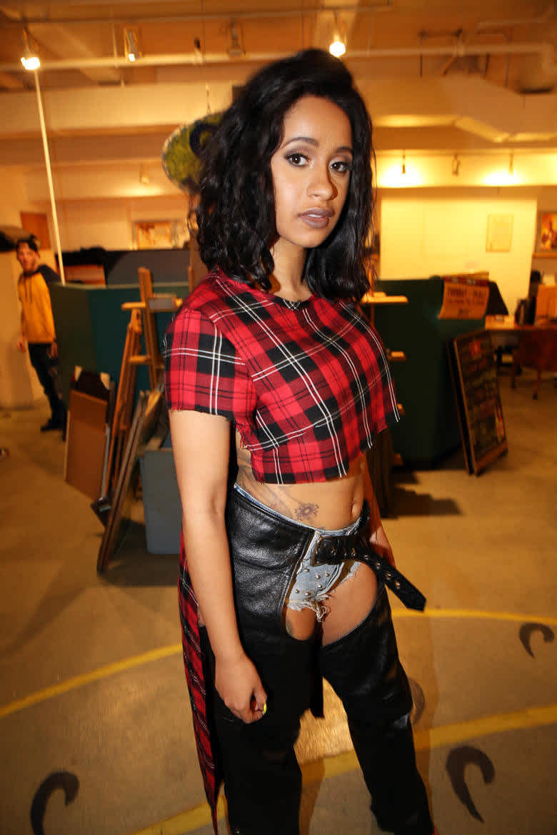 Cardi B with leather pants and plaid shirt